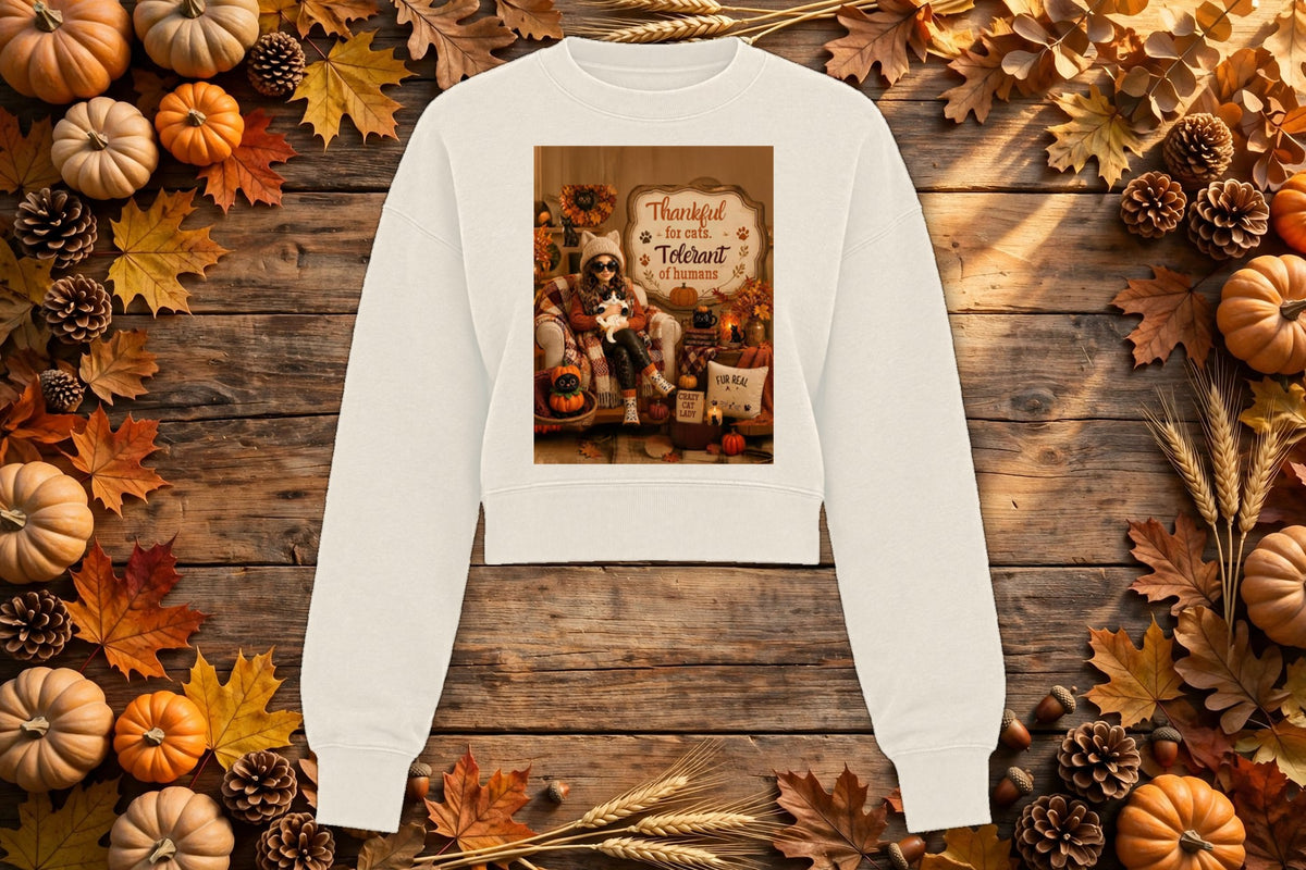 Thankful for Cats, Tolerant of Humans cropped crewneck in cream, styled on an autumn flat lay